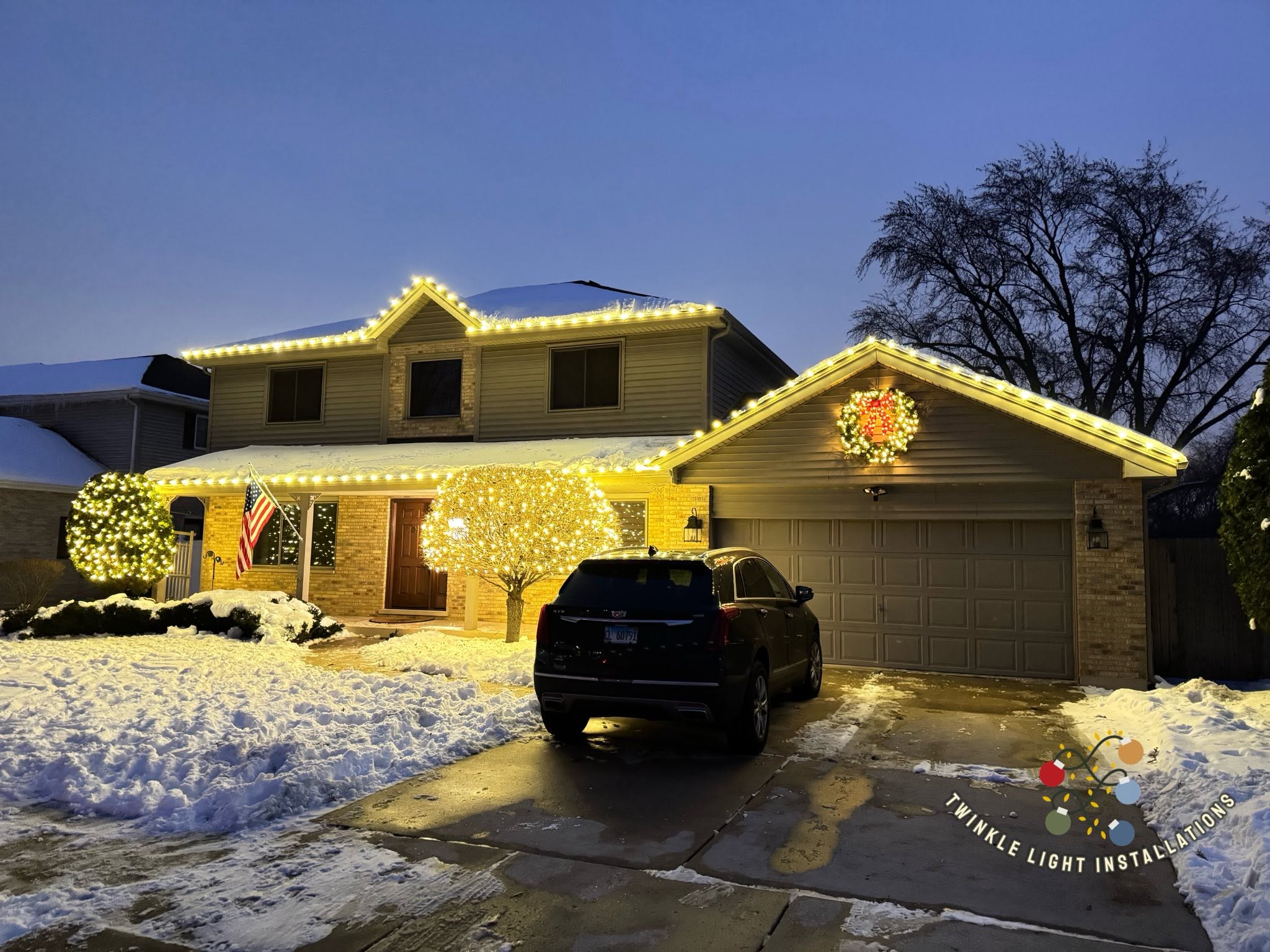 Large home with clean warm white Christmas lights across multiple roof peaks